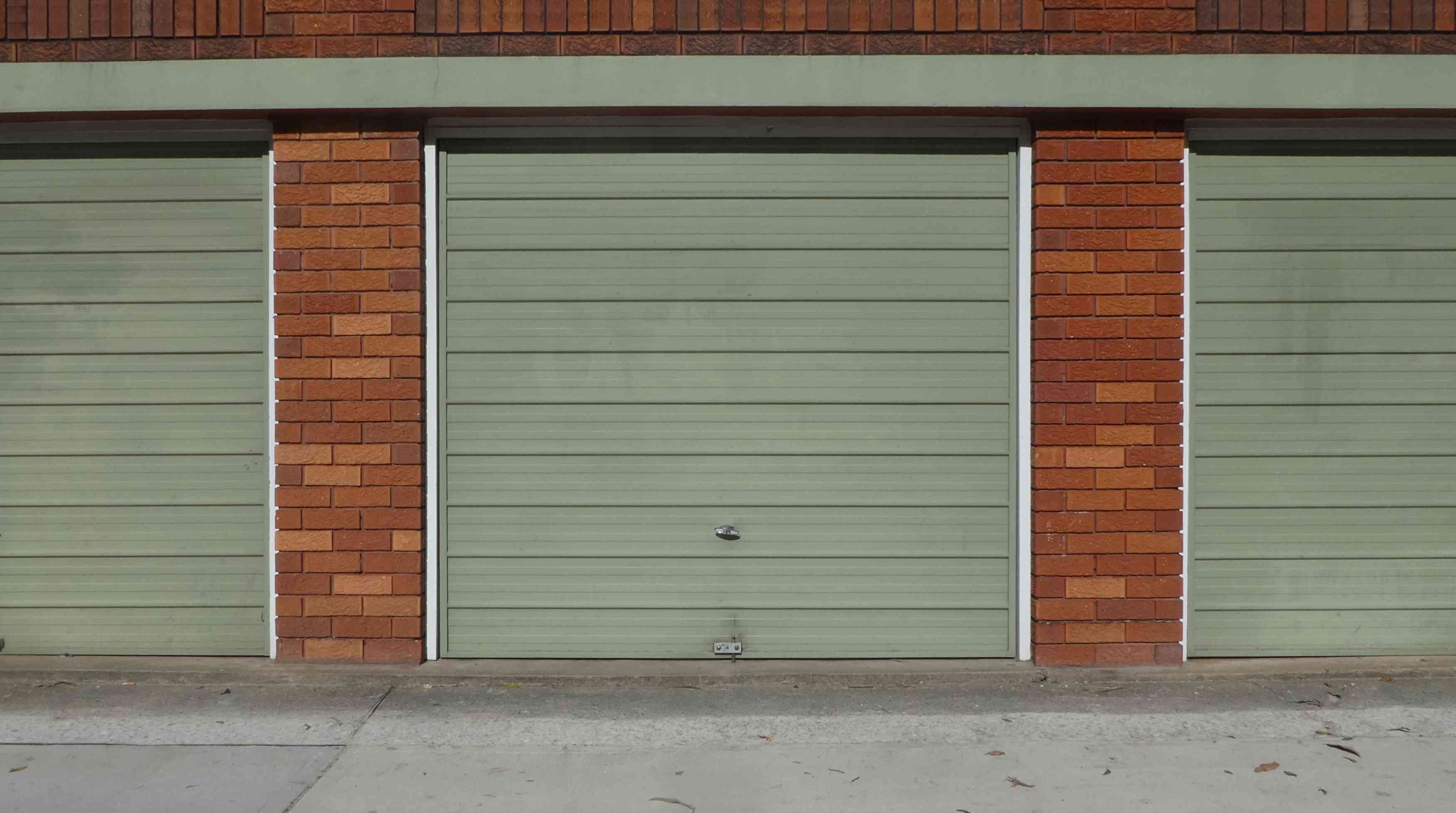 green-garage-door-brick-frame-street-view-2N8RDME(1) 3 Main Types of Garage Door Springs and Accessories | Automated Door Systems